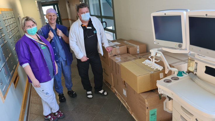 En kvinna och två män står bredvid hoppackad sjukvårdsutrustning