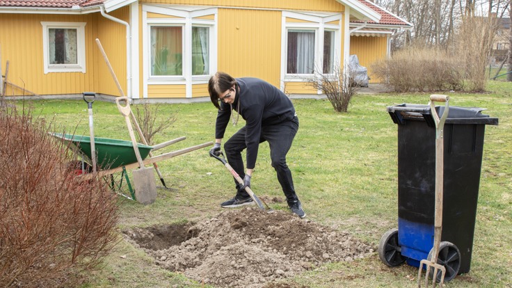Deltagare som gräver en grop i trädgården