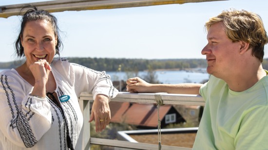 Kvinna och man i solen på en balkong